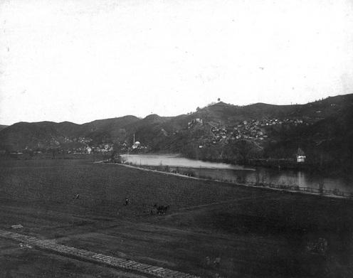 Maglaj dél felől, Joseph Löwy fotóján 1878-ban. A huszárok is ezen a Boszna menti úton haladtak, a végzetes útkanyarulat valahol a kép bal oldalán a távolban látható házcsoport környékén lehetett. Az előtérben lévő táj kicsit megtévesztő, a támadás idején még ennél jóval tagoltabb volt, valószínűleg a kép bal sarkában látható épülő vasút kedvéért számolták fel a sövényeket és kerítéseket.