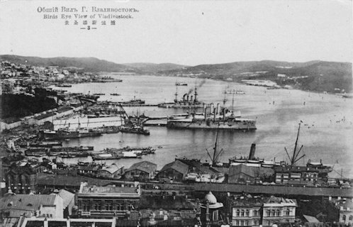 Képeslap, amely a vlagyivosztoki kikötőt, a Zolotoy Rog (Arany-szarv) öblöt ábrázolja madártávlatból, 1918-1920 körül. A cirill orosz, majd angol felirat és a harmadik sorban lévő kínai/japán írásjegyek arra utalnak, hogy a képeslapot a Távol-Keleten állomásozó nemzetközi erők vagy külföldiek számára nyomtatták. A vízen jól láthatók a horgonyzó, többkéményes gőzhajók és az antant szövetségesek (amerikai, japán, brit, kanadai és francia) hadihajói.